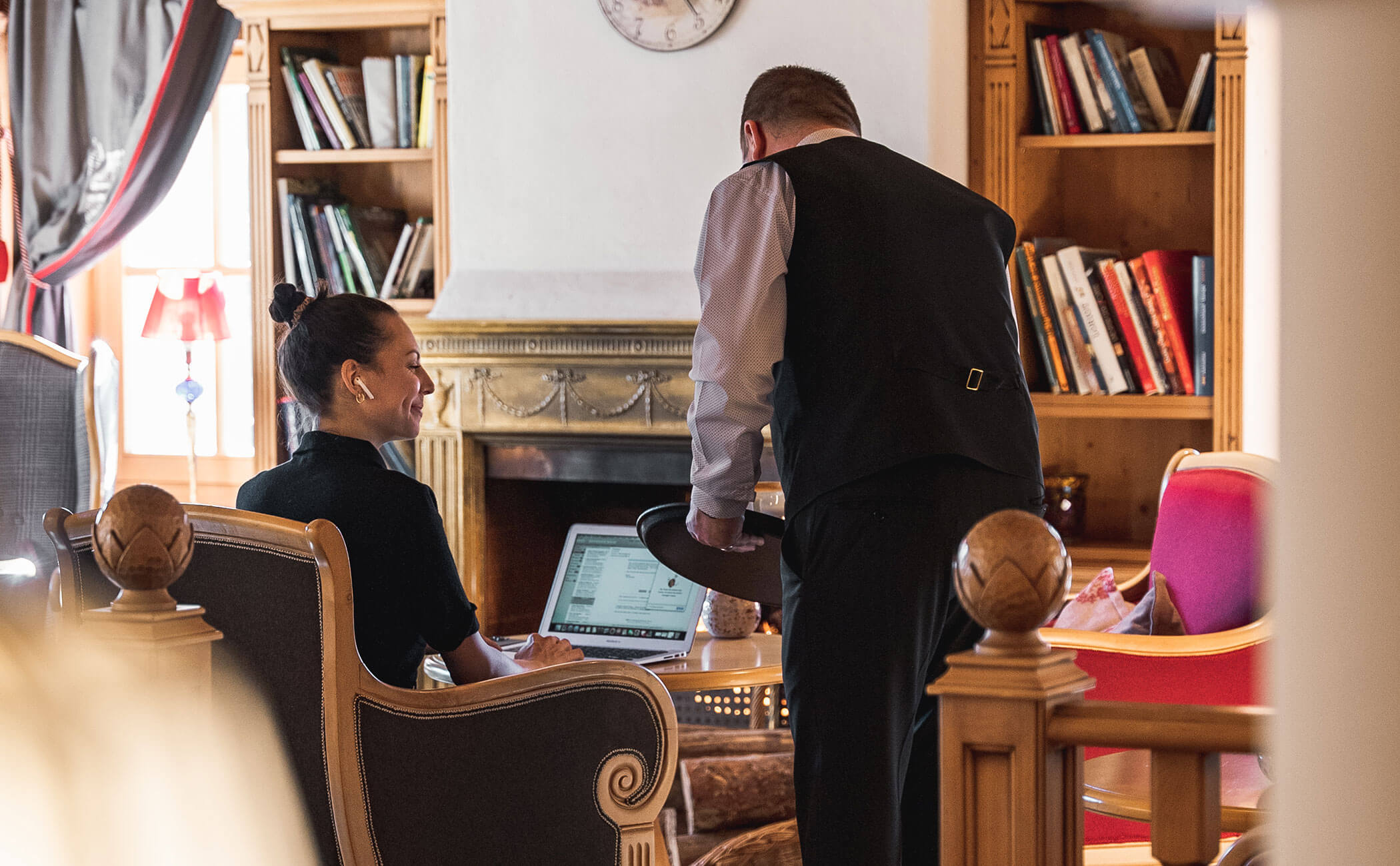 Un cameriere serve una donna che lavora al computer nell'area bar - Vitalhotel Erica