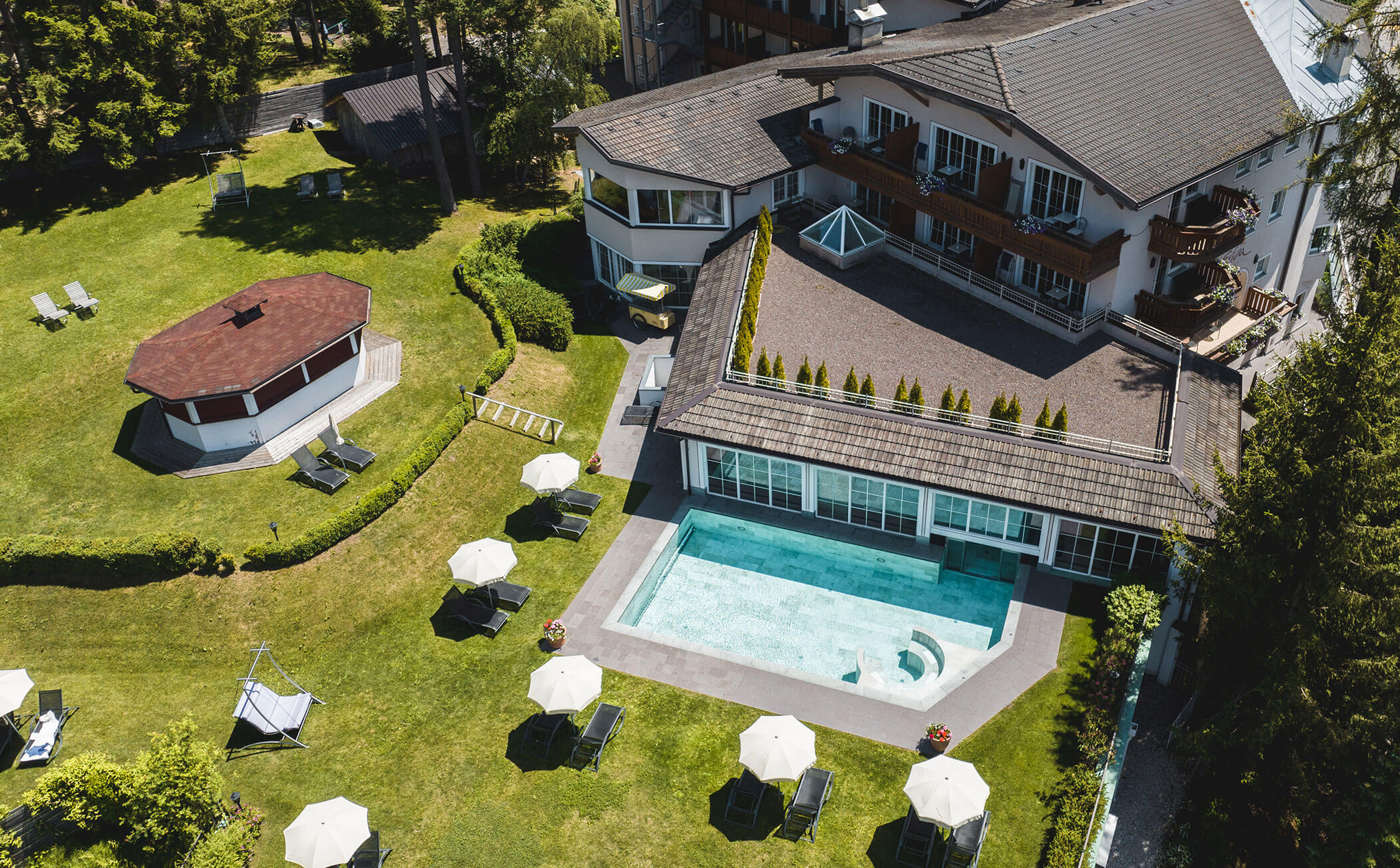 Vista dall'alto del prato per prendere il sole e della piscina all'aperto in estate - Vitalhotel Erica