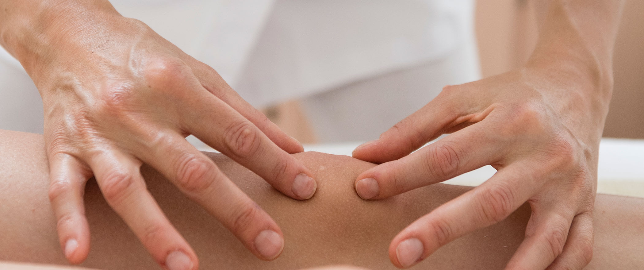 Due mani che massaggiano un ginocchio con la tecnica Bowen - Vitalhotel Erica