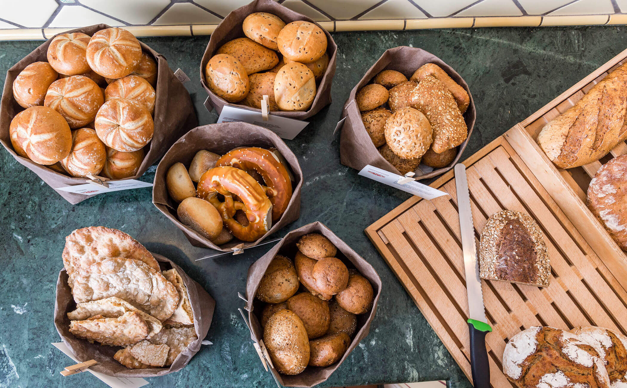 Diversi tipi di pane, tagliere e coltello da pane - Vitalhotel Erica