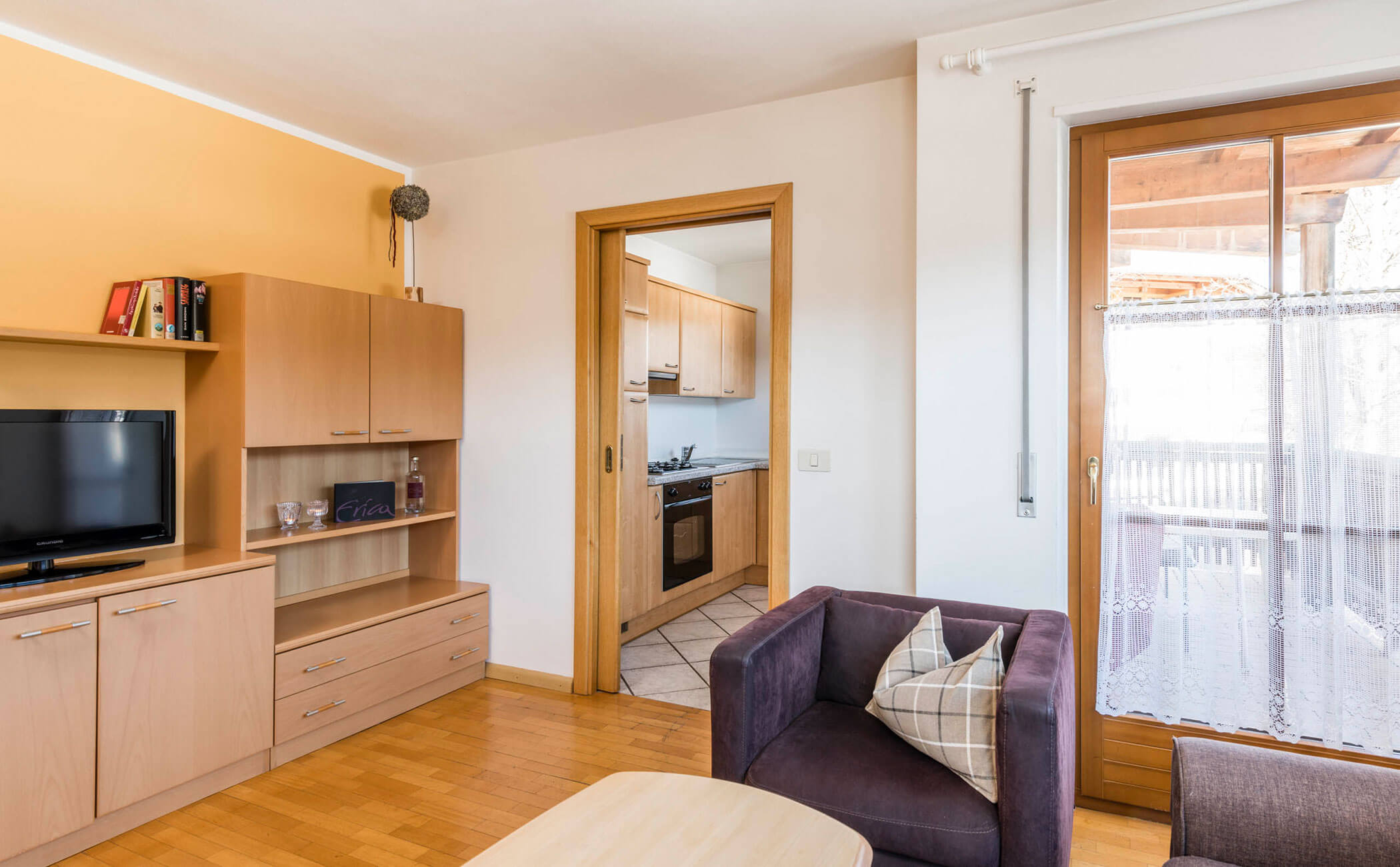 Zona giorno con TV e piccola cucina nell'appartamento vacanze - Vitalhotel Erica