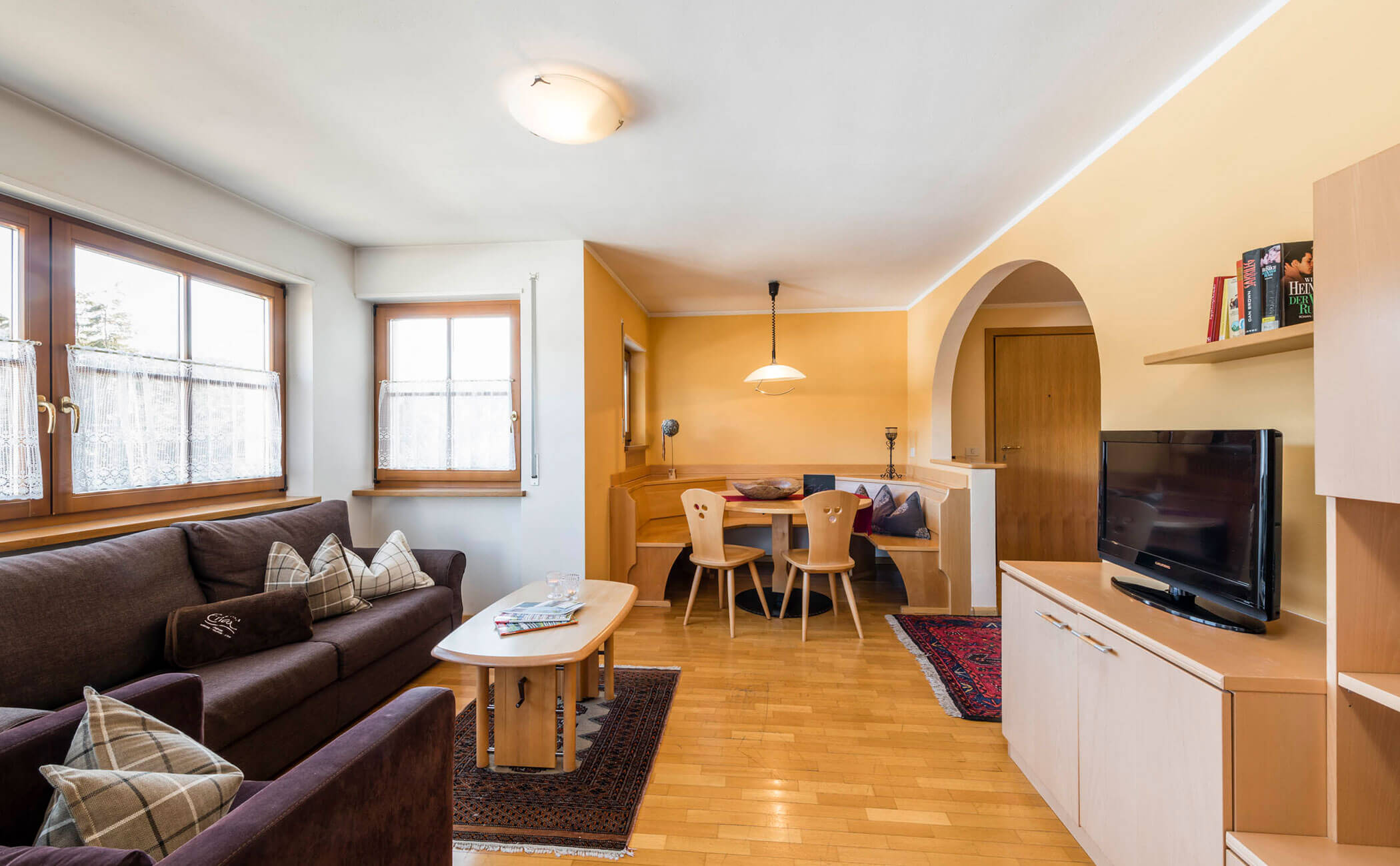 Divano scuro con diversi cuscini e zona salotto nell'appartamento vacanze - Vitalhotel Erica