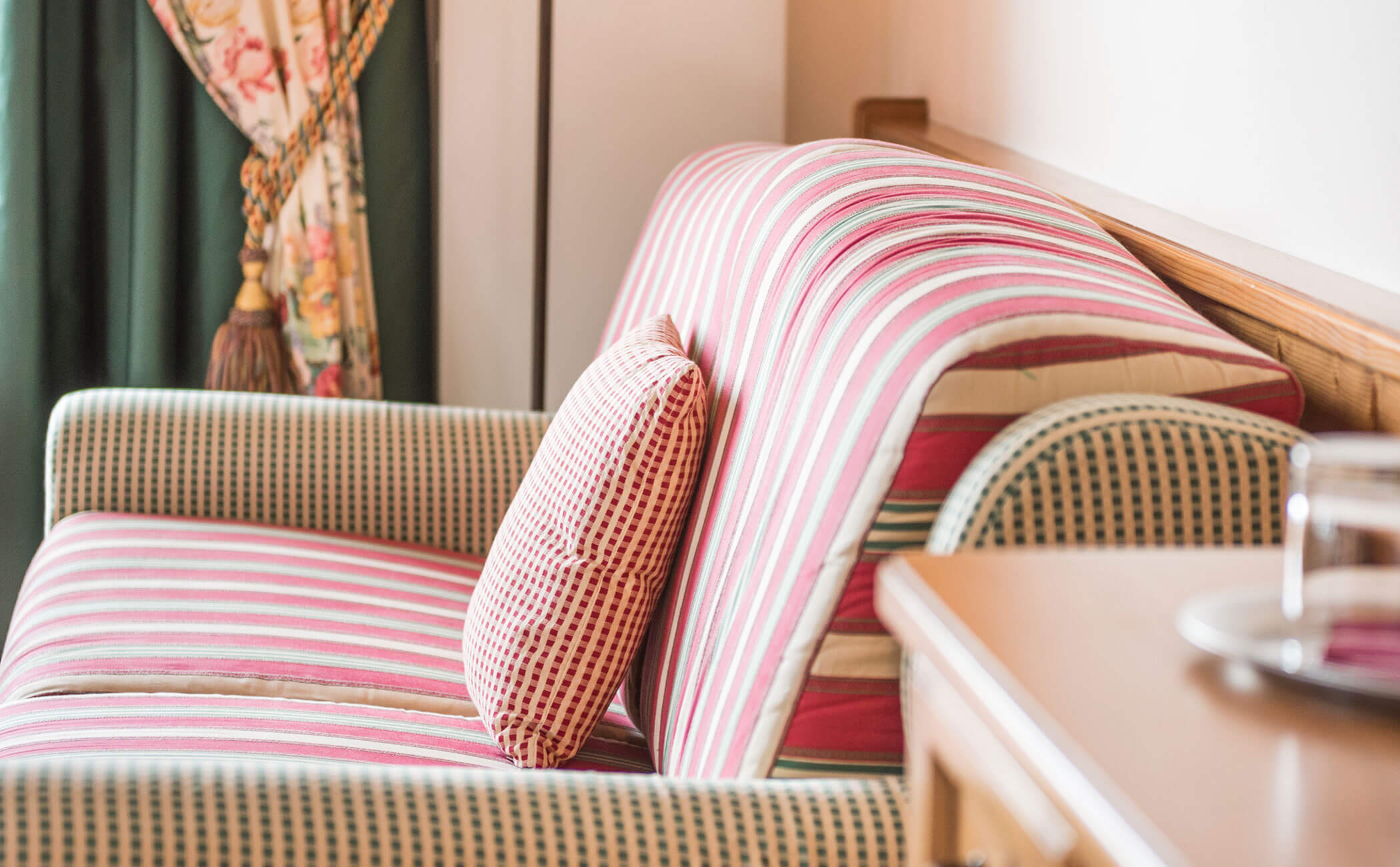 Divano a motivi rosso-verde-beige nella junior suite Rosengarten Residence - Vitalhotel Erica