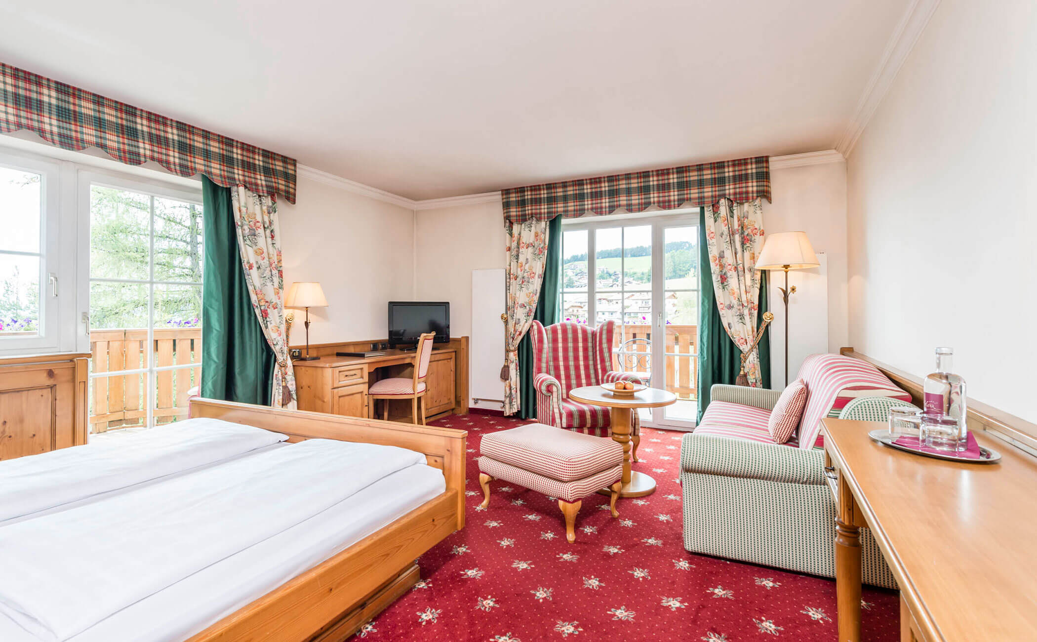 Letto matrimoniale e zona giorno nella junior suite Rosengarten Residence - Vitalhotel Erica