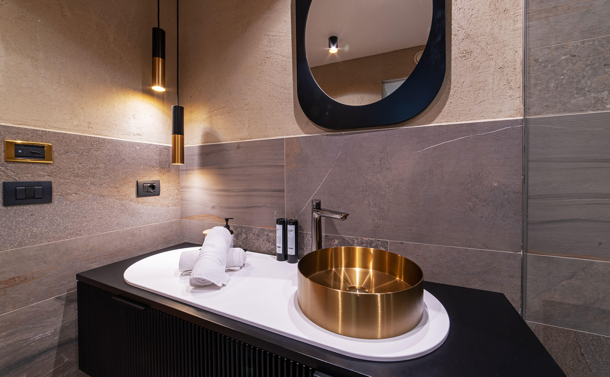Bagno con lavabo dorato e mobili neri nella camera Latemar comfort - Vitalhotel Erica