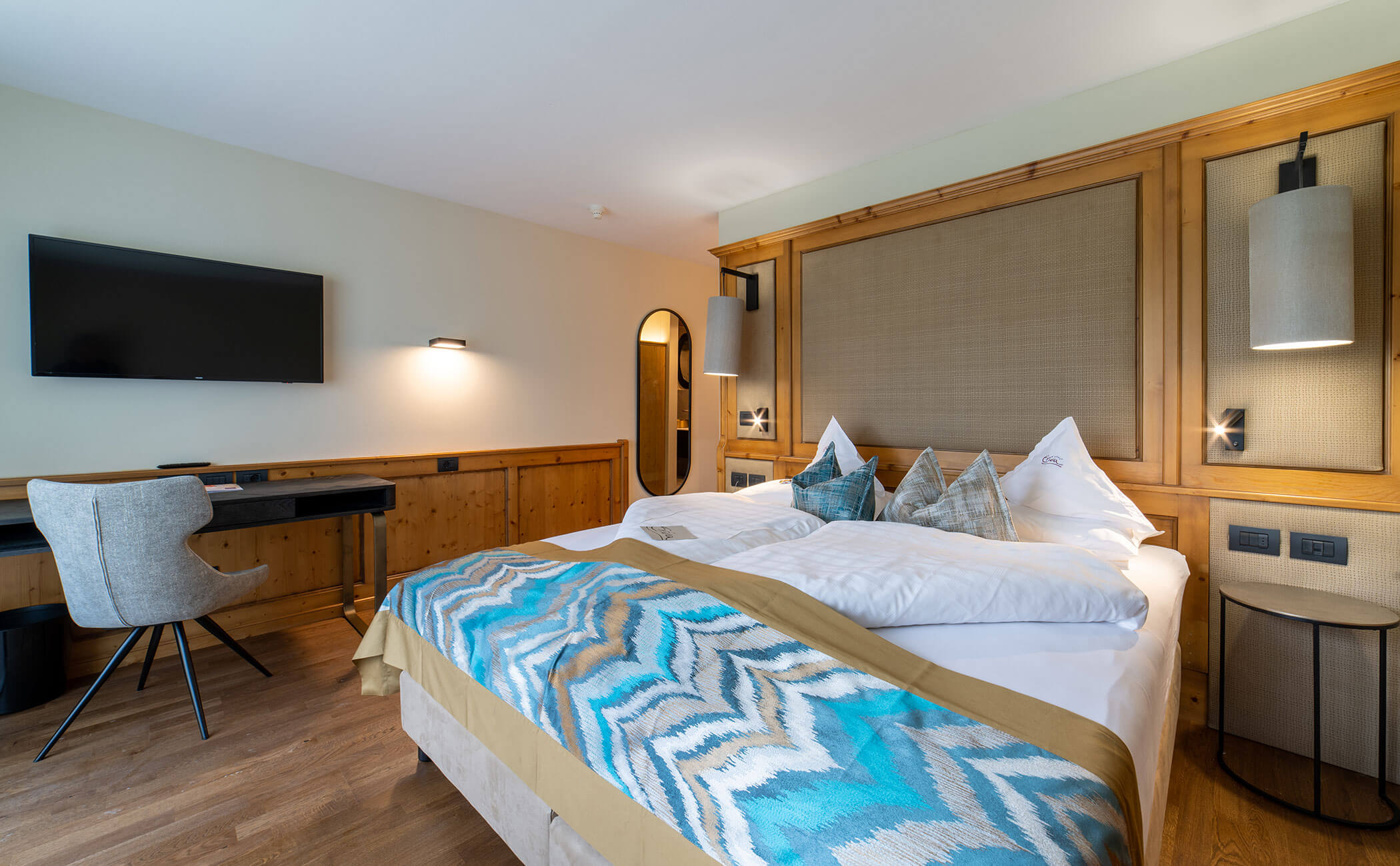 Letto matrimoniale con copriletto a fantasia nella camera Latemar comfort - Vitalhotel Erica