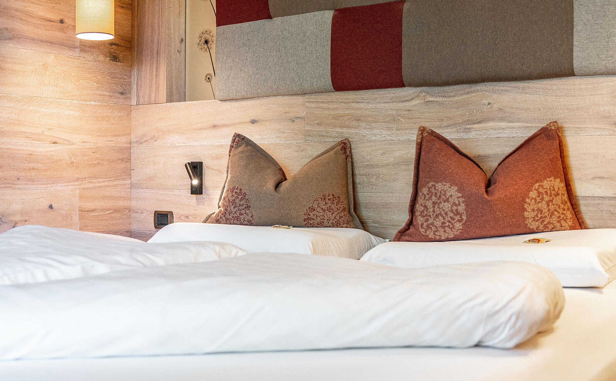 Letto matrimoniale con cuscini decorativi colorati nella camera Erica comfort - Vitalhotel Erica