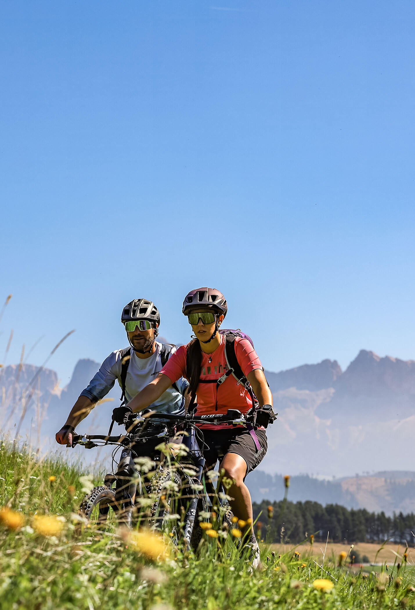 Una coppia in mountain bike tra i prati alpini in estate - Vitalhotel Erica
