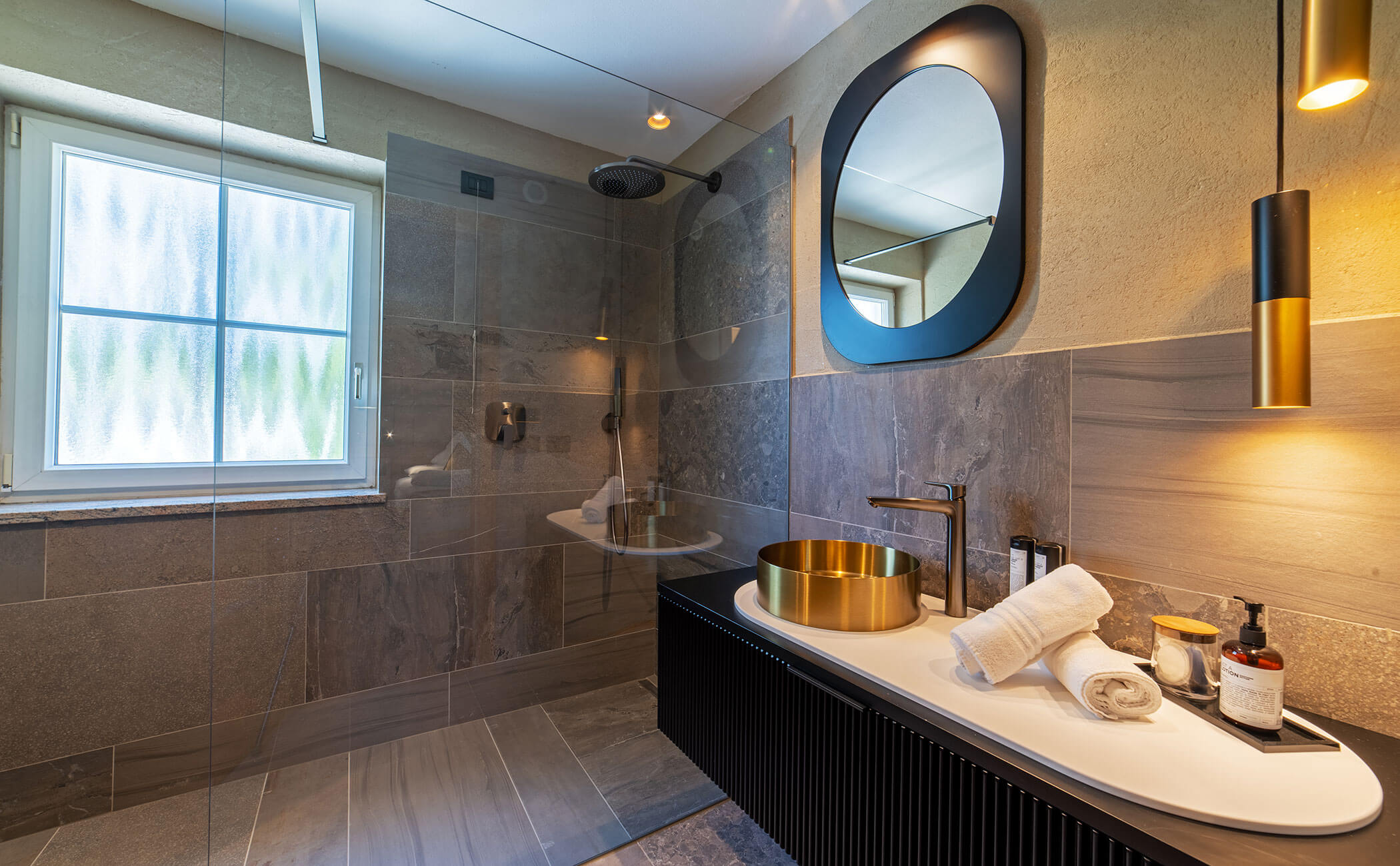 Bagno moderno con lavabo dorato e mobili neri nella camera Latemar Superior - Vitalhotel Erica