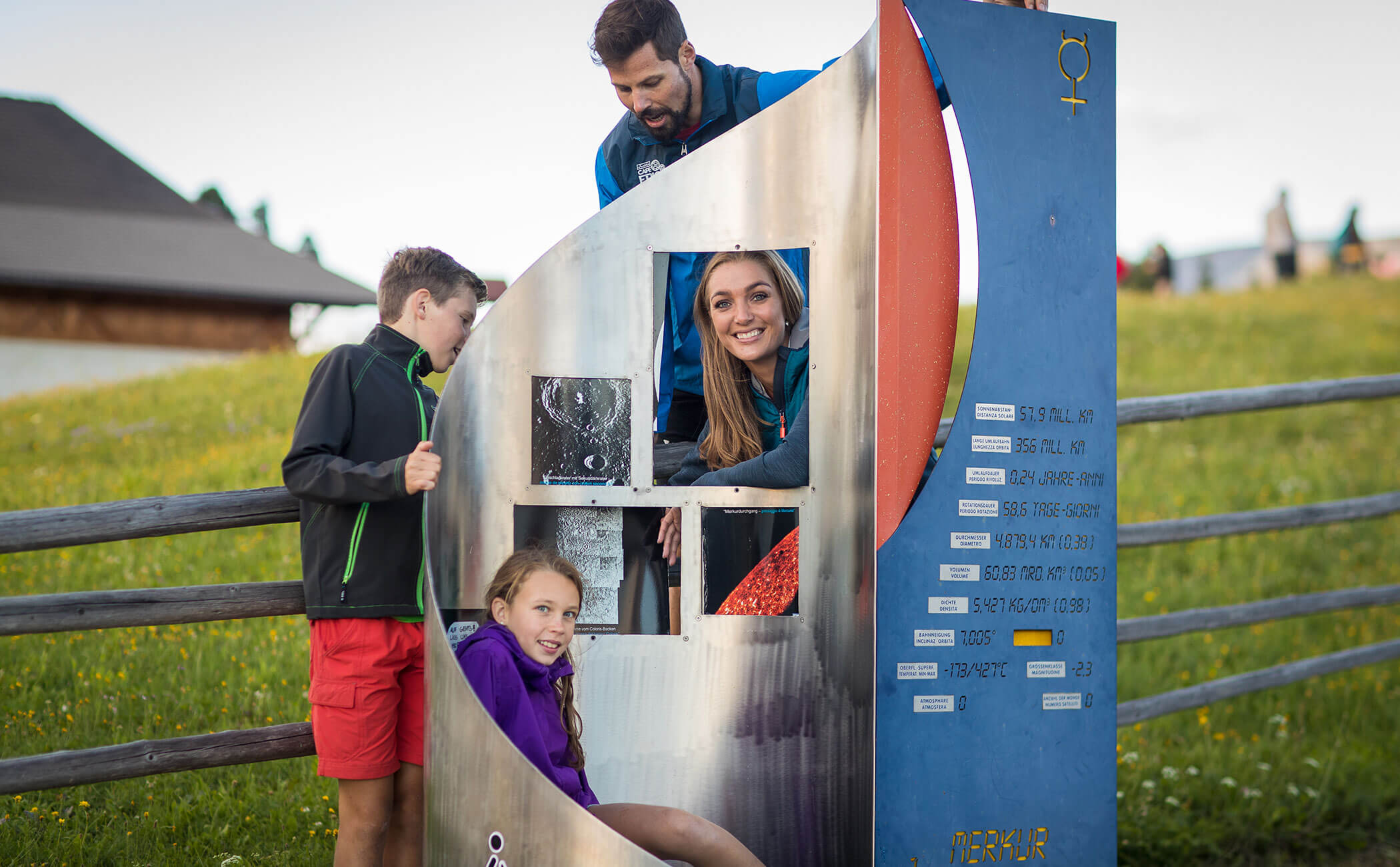 Una famiglia davanti a un pannello informativo sul Sentiero dei pianeti - Vitalhotel Erica