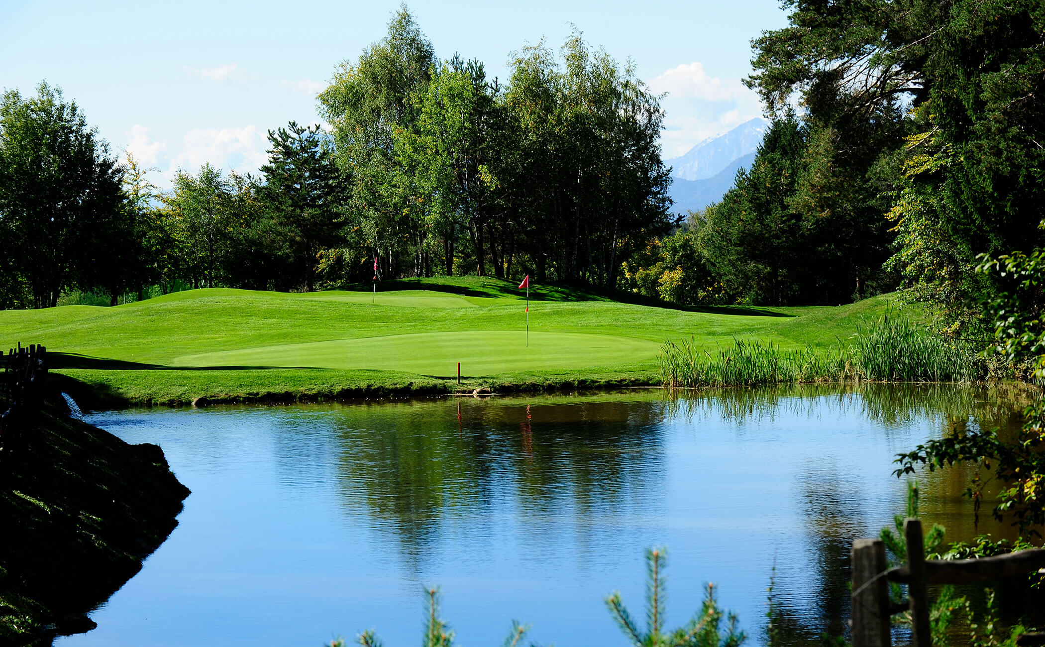 Un laghetto di fronte al campo da golf con diverse buche -Vitalhotel Erica