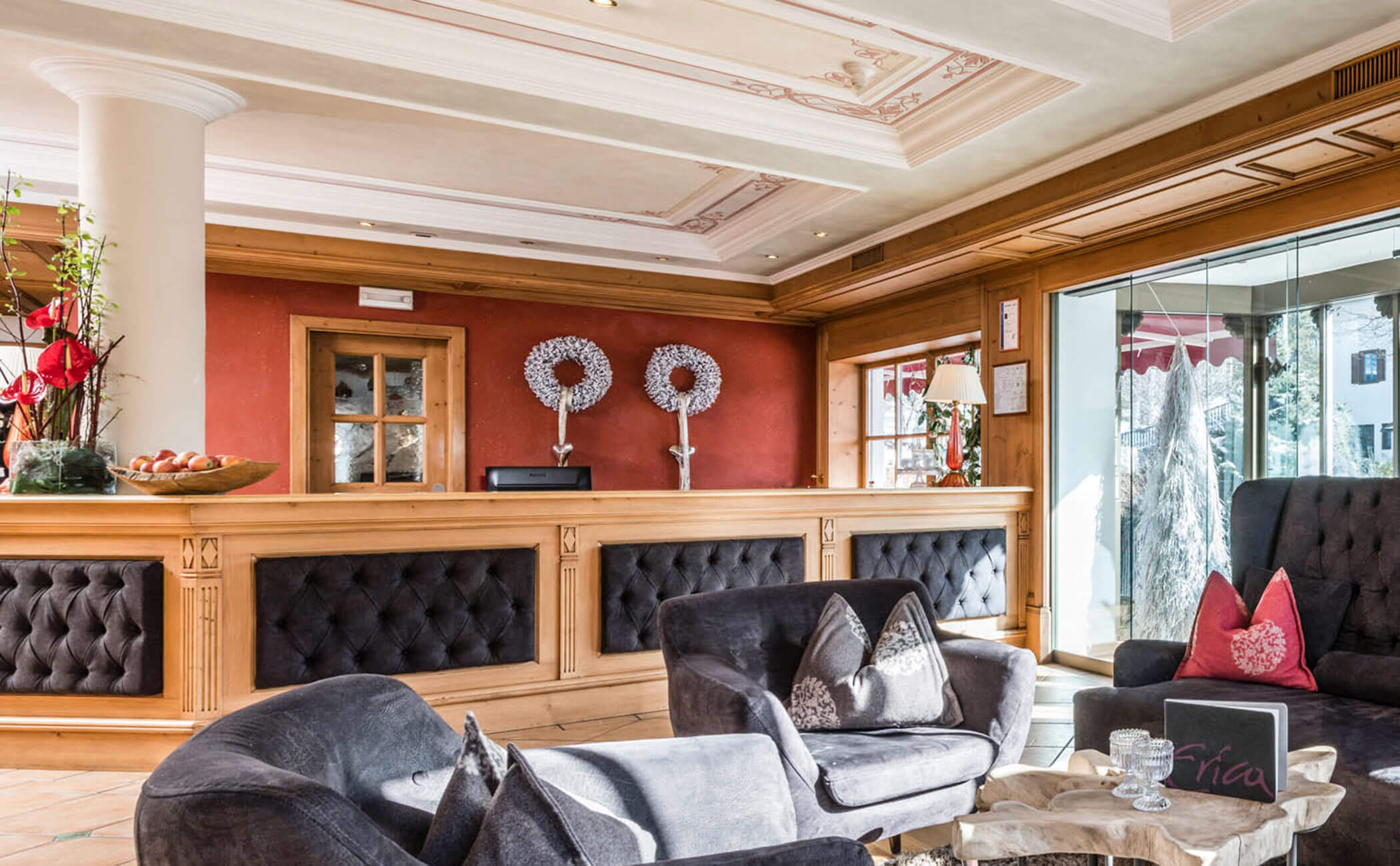 Un divano scuro e il bancone della reception - Vitalhotel Erica