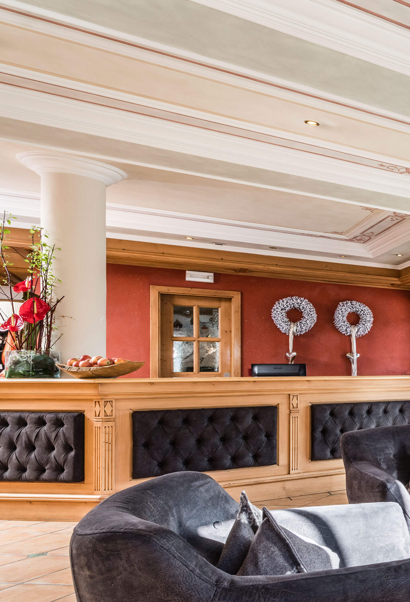 A dark sofa and the counter at reception - Vitalhotel Erica