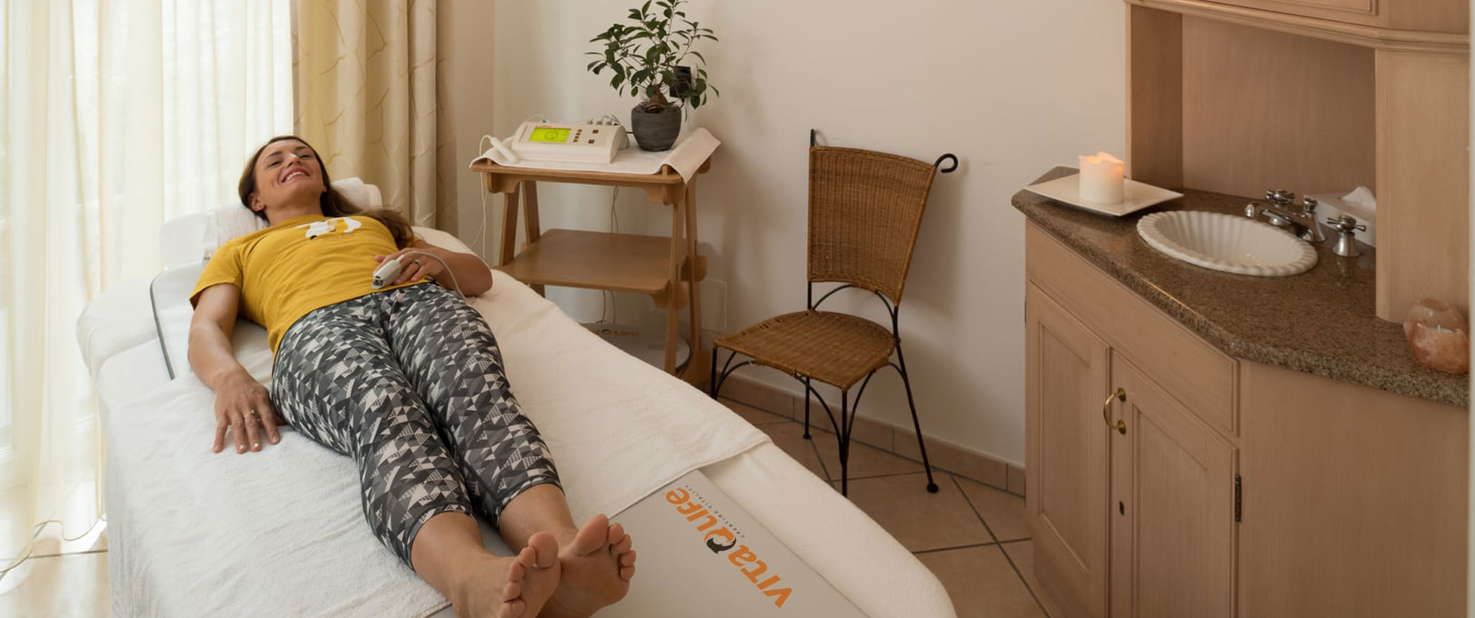 Una donna si sdraia su un lettino durante un trattamento di risonanza magnetica - Vitalhotel Erica