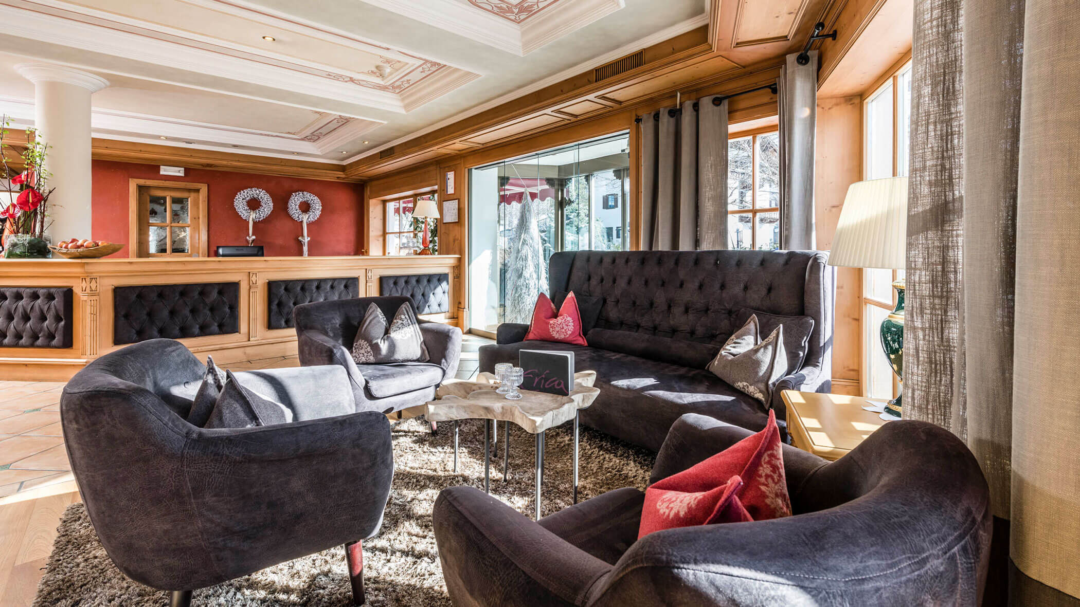 Lobby con diverse poltrone e divani, alle spalle la reception - Vitalhotel Erica