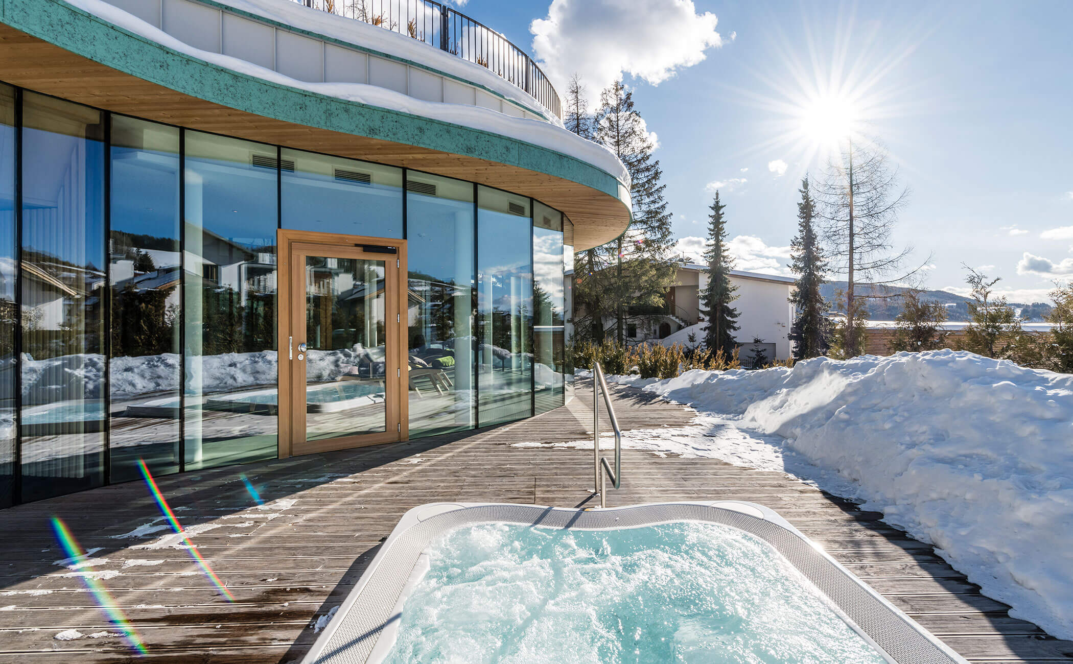 La vasca idromassaggio all'aperto in inverno, alle sue spalle la vista sulla sala relax - Vitalhotel Erica