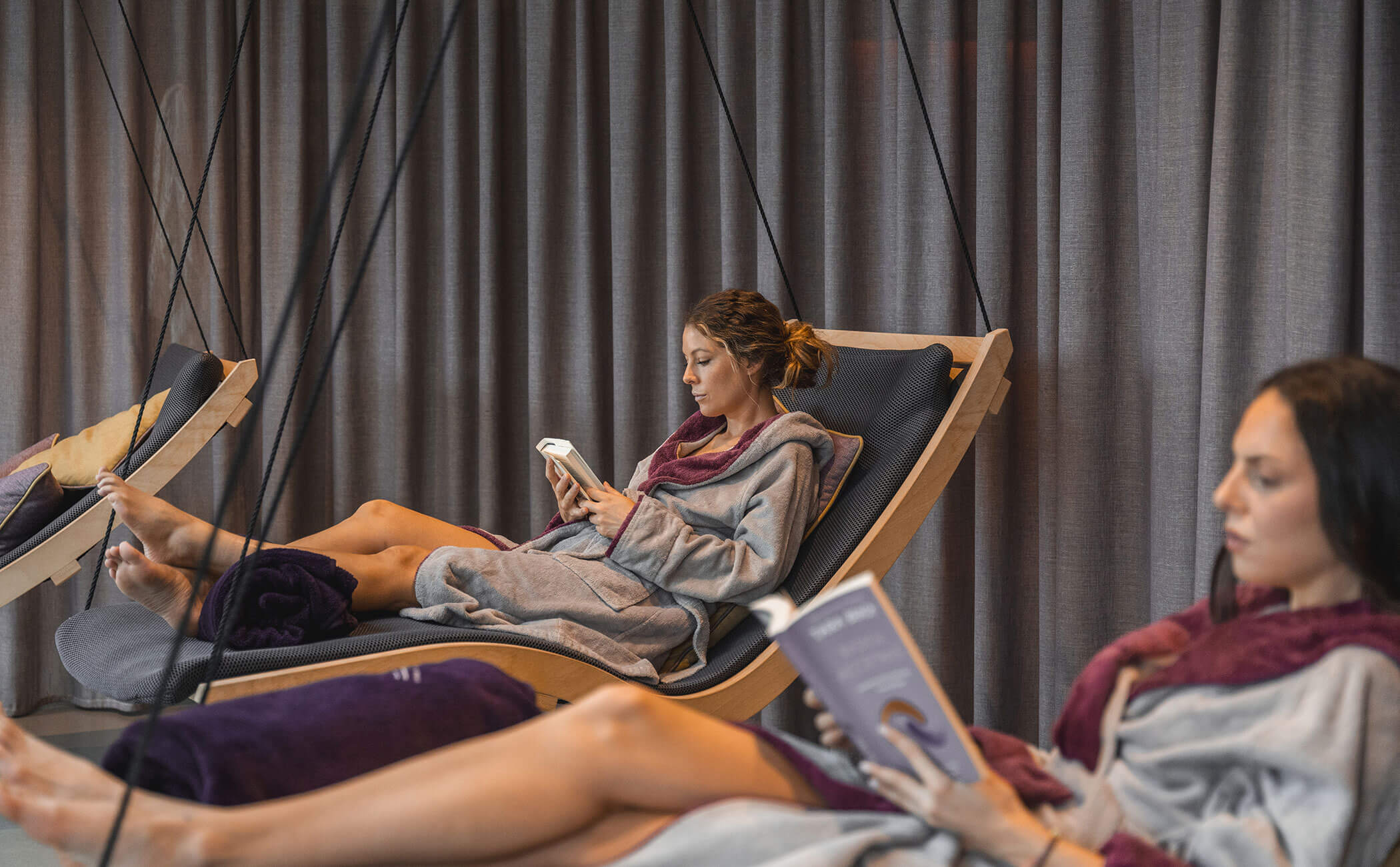 Due donne si rilassano nella sala relax leggendo un libro - Vitalhotel Erica