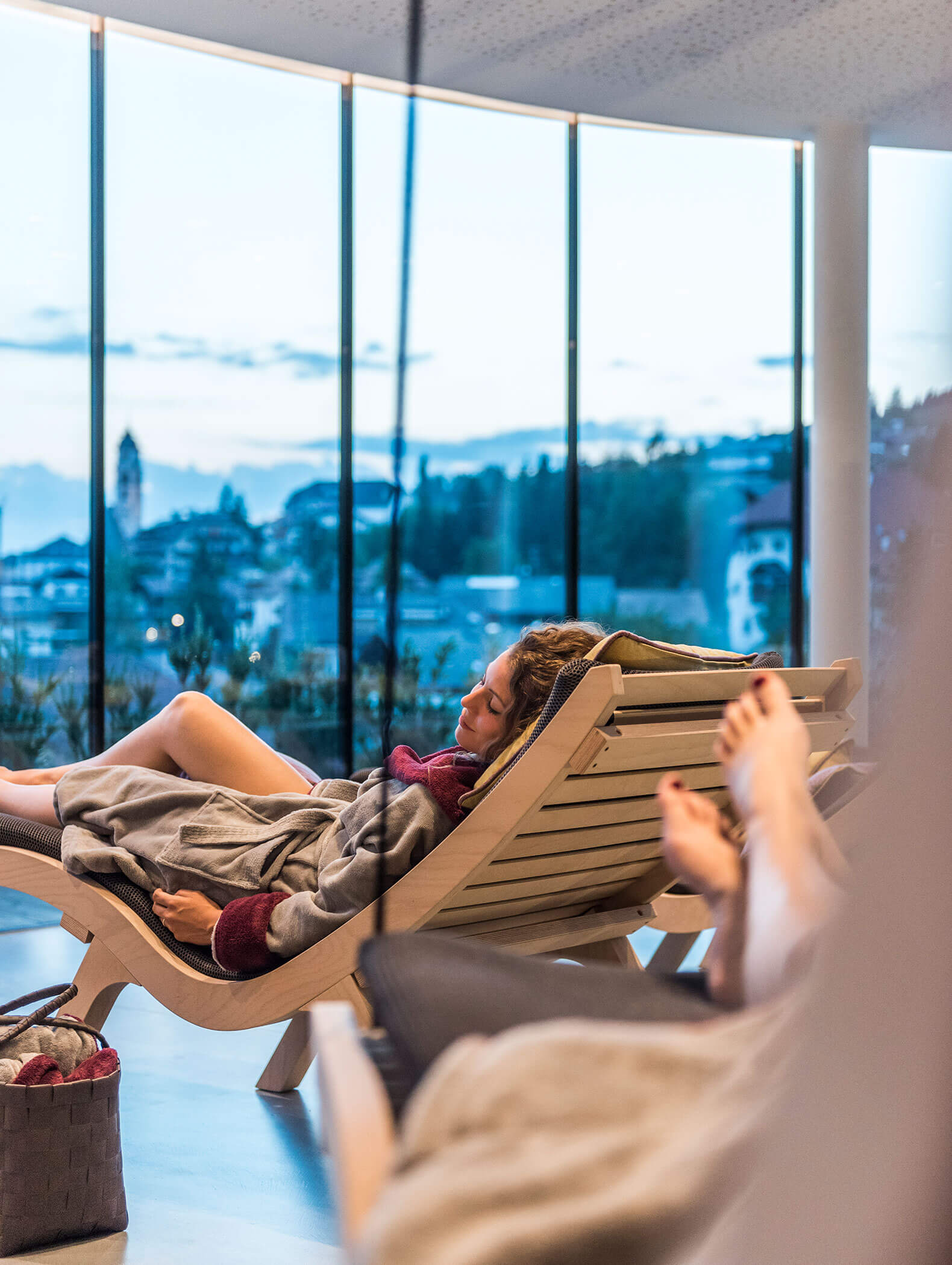 Una donna in accappatoio si rilassa su un lettino nella sala relax - Vitalhotel Erica