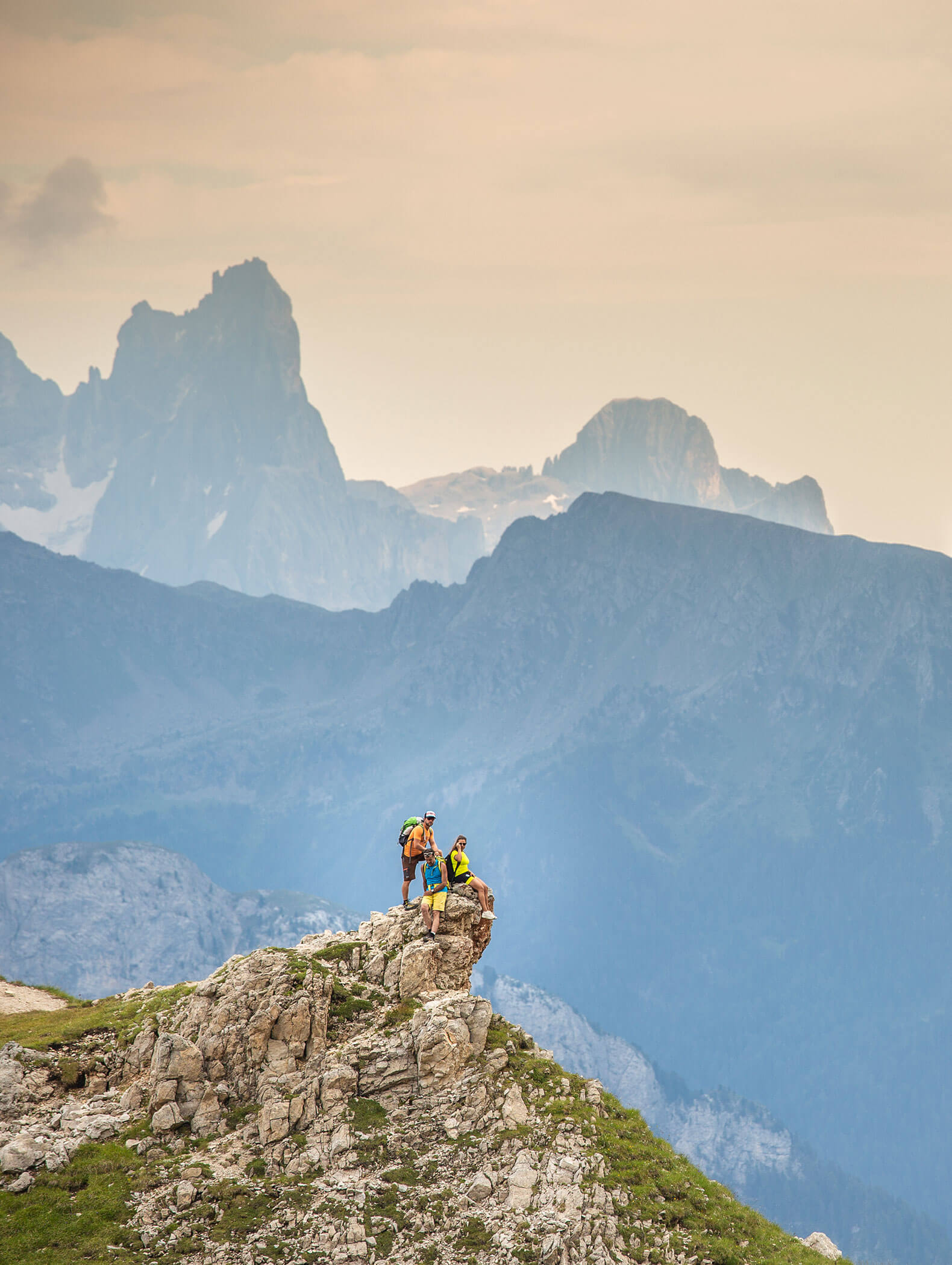 Tre escursionisti in montagna, alle loro spalle le suggestive cime delle Dolomiti - Vitalhotel Erica