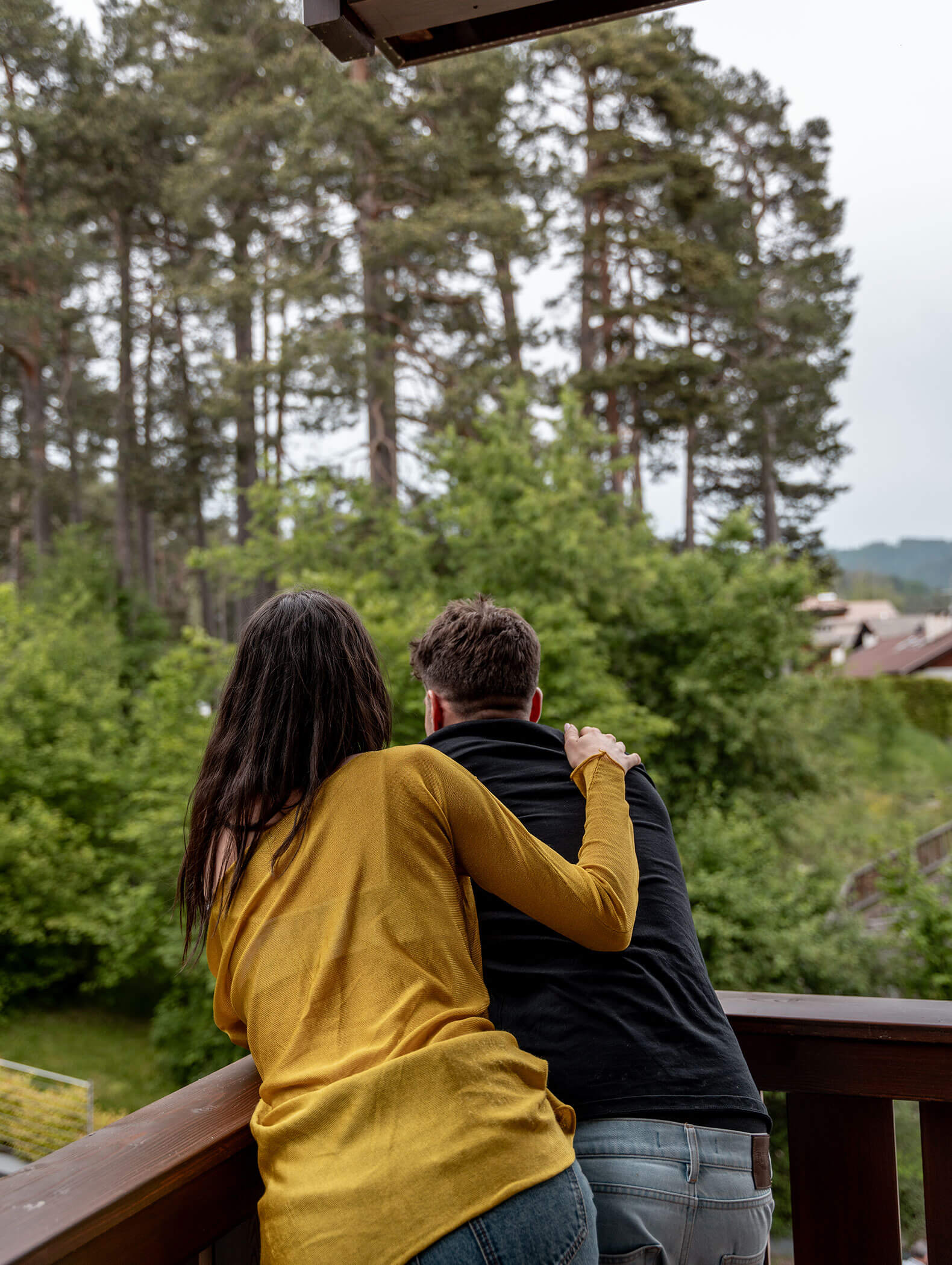 Una coppia si affaccia sul balcone e guarda il bosco - Vitalhotel Erica