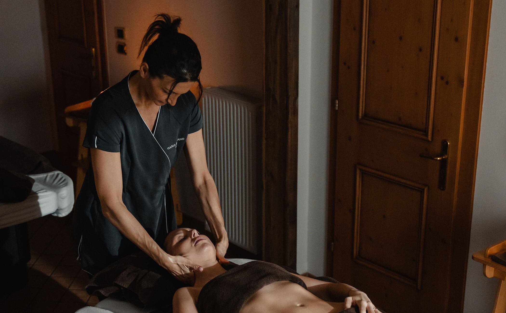 Una massaggiatrice massaggia il collo di una donna - Vitalhotel Erica