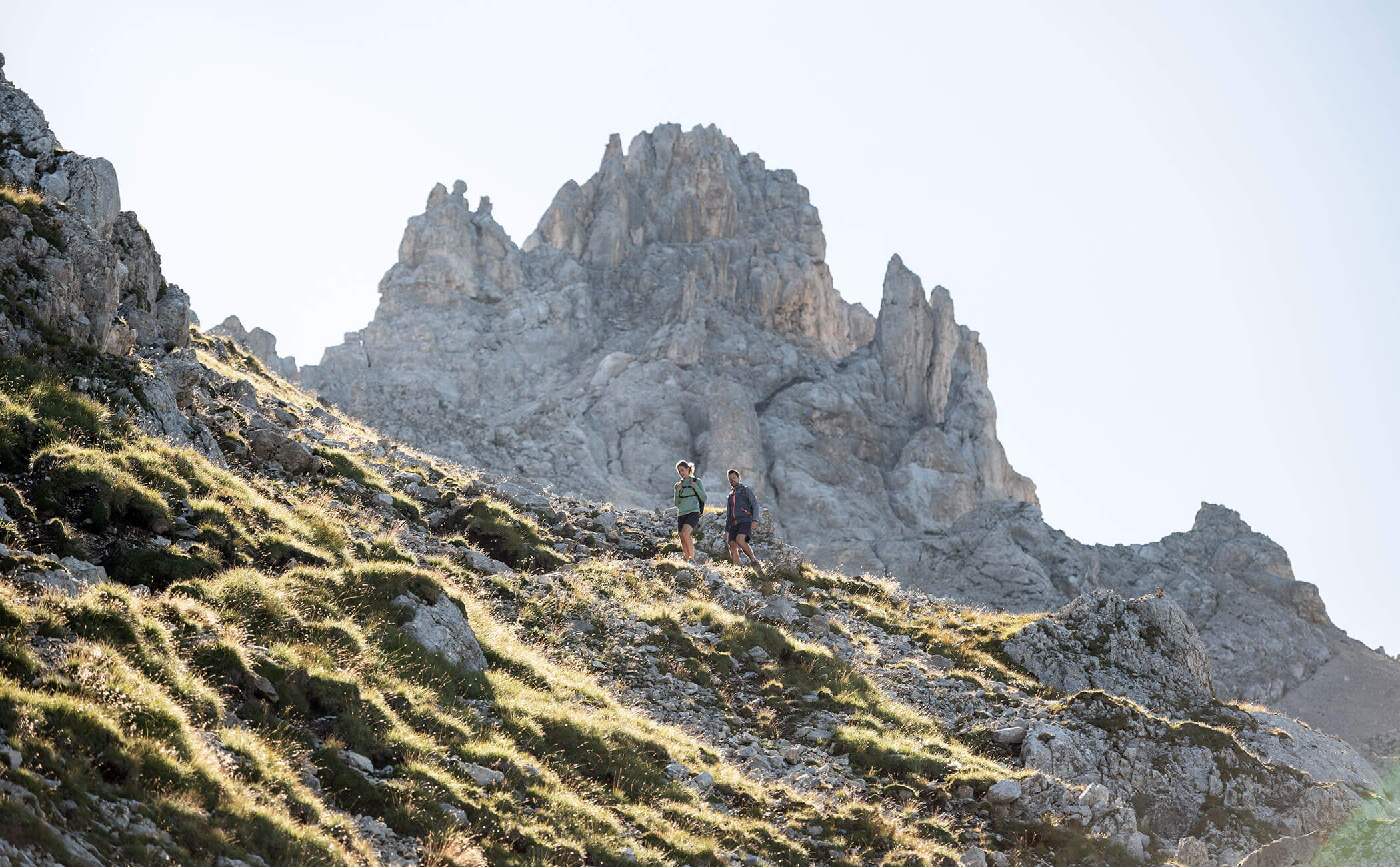 Una coppia di escursionisti nelle Dolomiti scende da uno stretto sentiero - Vitalhotel Erica
